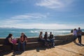 Biarritz, France - May 20, 2017: people sitting down and enjoying spring warm sun on atlantic coastline in basque country in sunny Royalty Free Stock Photo