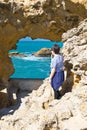 Biarritz, France - May 20, 2017: young boy looking through sea cave hole admiring beautiful view on atlantic ocean with waves in b