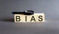 BIAS Word block fine and magnifying glass on gray background. Income, expenses, tax, financial