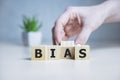 Bias - word from wooden blocks with letters, personal opinions prejudice bias concept, random letters around, white