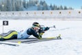 Biathlete lies and shoots a target at a 20 km race