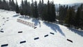 A biathlete in a tracksuit skis with poles during training on a cross-country track. Aerial view. Following an adult