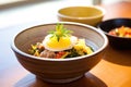 bibimbap in a stone bowl with a raw egg yolk on top