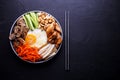 Bibimbap is a traditional dish of Korean cuisine on a dark background Royalty Free Stock Photo