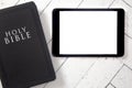 Bible and Blank Tablet on a White Wooden Surface