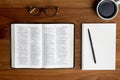 Bible with glasses, notebook, pencil and coffee over the wooden table. Royalty Free Stock Photo