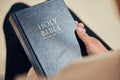 Bible, hands and person in prayer, religion and peace in a lounge, praise and holy worship for guidance. Closeup