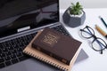 Bible and laptop on the work table with glasses. Holy Bible Study Online