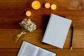 Bible with notebook, candlelight and flower over the wooden background. Royalty Free Stock Photo