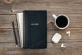 Bible, notebook, coffee cup and earphones on wooden background, top view.