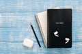 Bible, notebook and earphones on a blue wooden background, flat lay.