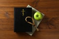 Bible, rosary beads and apple on wooden table, flat lay. Lent season Royalty Free Stock Photo