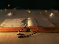 Bible and rosary beads in candlelight bokeh light background
