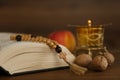 Bible, rosary beads, walnuts and apple on wooden table, closeup. Lent season Royalty Free Stock Photo