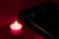 Bible with Rosary and Candle on a Red Table Cover Royalty Free Stock Photo