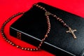 Bible and Rosary with Crucifix on a Red Background Royalty Free Stock Photo