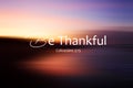 Bible verse inspirational quote - Be thankful. Colossians 3:15 On colorful abstract background illustration of blur sunrise sky