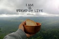 Bible verse quote - I Am the Bread of Life. John 6:35 With hand of a person holding bread on wooden bowl, mountain background. Royalty Free Stock Photo