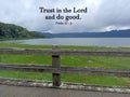 Bible verse quote - Trust in the Lord and do good. Christianity religious concept with wooden fence of bridge on lake. Royalty Free Stock Photo