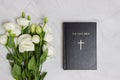 Bible with white roses over marble background with notebook. Royalty Free Stock Photo