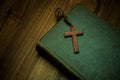 Bible with a wooden cross over the wooden table. Royalty Free Stock Photo