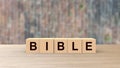 Bible word wooden cubes on table vertical over blur Wall of bricks background, mock up, template, Christianity and Catholicism, Royalty Free Stock Photo