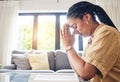 Bible, worship and woman praying in her living room for hope, help or forgiveness at home. Hands, book and Christian