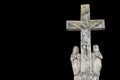 Biblical history: crucifixion of Jesus Christ, and Virgin Mary and Mary Magdalene. Ancient stone statue isolated on black Royalty Free Stock Photo