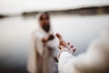 Biblical scene - of Jesus Christ lending a hand to a female with a blurred background Royalty Free Stock Photo