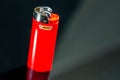 Bic cigarette lighter on dark reflecting surface close up macro shot.