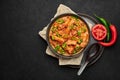 Bicol Express Stew in black bowl on dark slate table top. Filipino cuisine spicy pork belly coconut milk curry Royalty Free Stock Photo