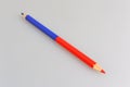 Bicoloured red and blue pencil on gray Royalty Free Stock Photo