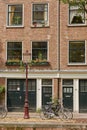 Bicycle as popular way of transport in Amsterdam Netherlands parked and locked in front of traditional house in Holland