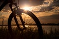 Bicycle on the background of a summer evening landscape. Silhouette of a bicycle in the grass near the lake Royalty Free Stock Photo