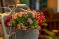 Bicycle basket full of colorful fabric flowers, in a corner of the cafe in warm vintage yellow Royalty Free Stock Photo