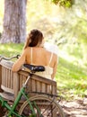 Bicycle, bench or woman in park to relax for wellness, nature or health on holiday vacation in autumn. Amsterdam, back