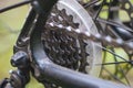 Bicycle chain close-up. Metal parts of the bike-chain, rear cassette, switch, brakes, gear levers on the background of blurred gra Royalty Free Stock Photo