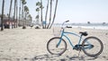 Bicycle cruiser bike by ocean beach, California coast USA. Summer cycle, lifeguard hut and palm tree Royalty Free Stock Photo