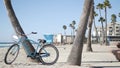 Bicycle cruiser bike by ocean beach, California coast USA. Summer cycle, lifeguard hut and palm tree Royalty Free Stock Photo