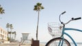 Bicycle cruiser bike by ocean beach, California coast USA. Summer cycle, lifeguard hut and palm tree