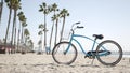 Bicycle cruiser bike by ocean beach, California coast USA. Summer cycle, lifeguard hut and palm tree Royalty Free Stock Photo