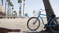 Bicycle cruiser bike by ocean beach, California coast USA. Summer cycle, lifeguard hut and palm tree Royalty Free Stock Photo