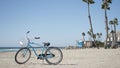 Bicycle cruiser bike by ocean beach, California coast USA. Summer cycle, lifeguard hut and palm tree Royalty Free Stock Photo