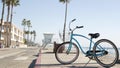 Bicycle cruiser bike by ocean beach, California coast USA. Summer cycle, lifeguard hut and palm tree Royalty Free Stock Photo