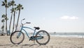 Bicycle cruiser bike by ocean beach, California coast USA. Summer cycle, lifeguard hut and palm tree Royalty Free Stock Photo