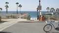 Bicycle cruiser bike by ocean beach, California coast USA. Summertime cycle, stairs and palm trees.