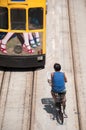 Bicycle delivery man following a tram along Hennessey Road, Hong Kong