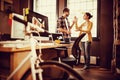 Bicycle by desk while business people discussing in background Royalty Free Stock Photo