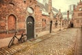 Bicycle at doors of brick houses of historical Beguinage, 13th century complex houses for beguines women