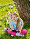 Bicycle girl wearing helmet watching at tablet pc in cycling. Royalty Free Stock Photo